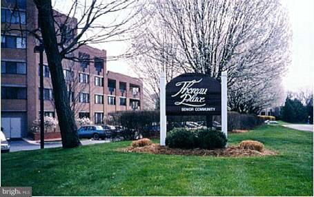 1951 Sagewood Lane, Unit 214 Reston, VA 20191 - Photo 22 of 23 a front view of a building with garden and trees