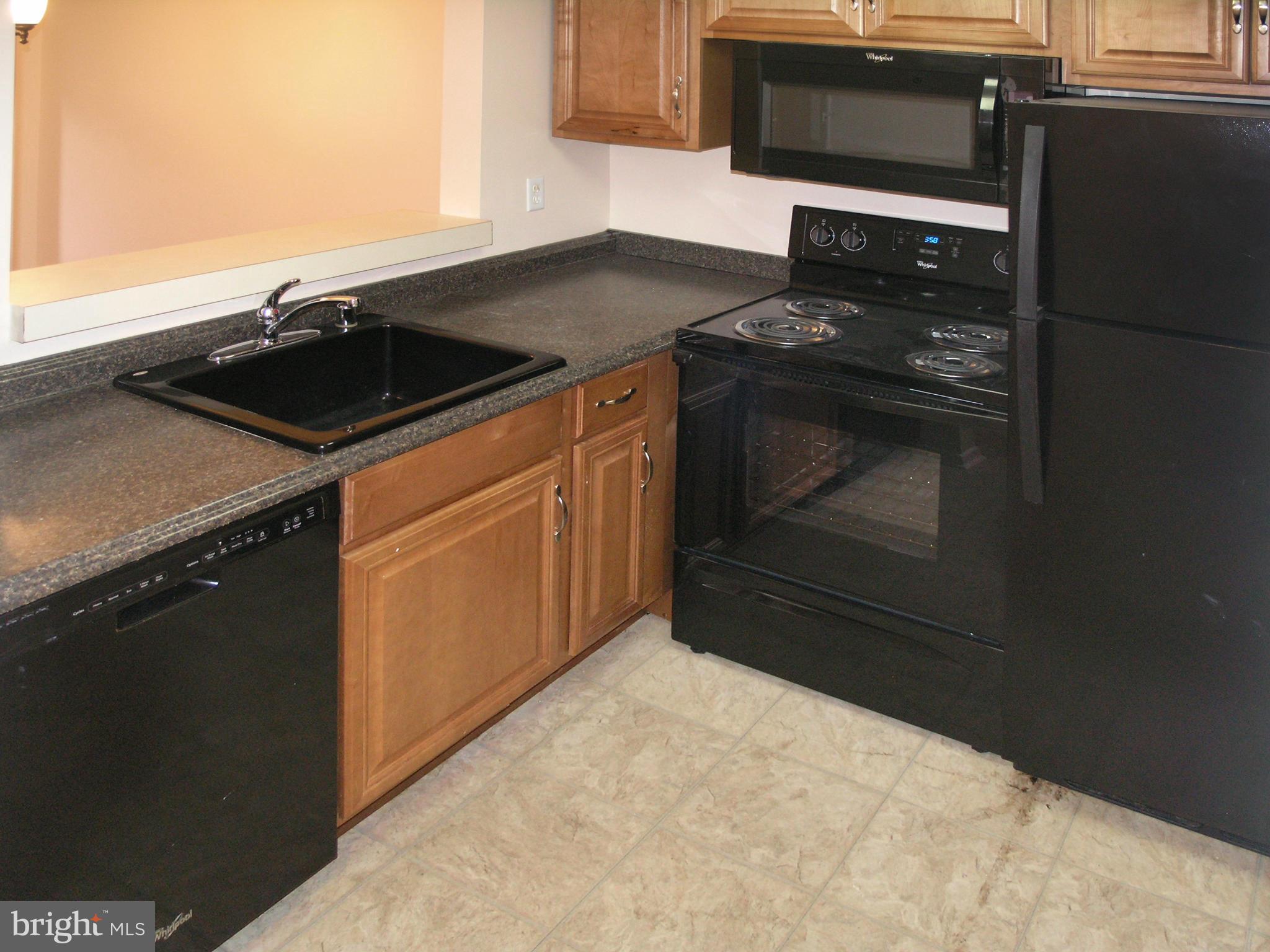 1951 Sagewood Lane, Unit 214 Reston, VA 20191 - Photo 7 of 23 a kitchen with a stove and a microwave