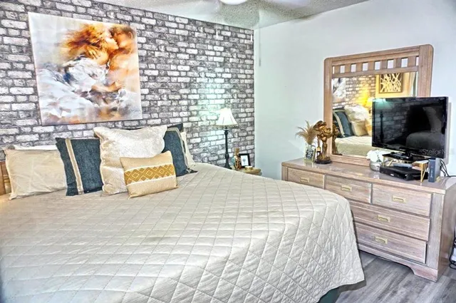 a bedroom with a bed and a flat tv screen on the dresser