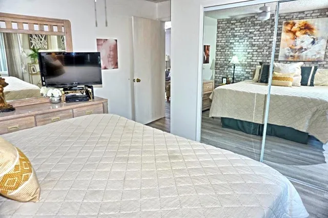 a bedroom with a bed and a flat tv screen on dresser