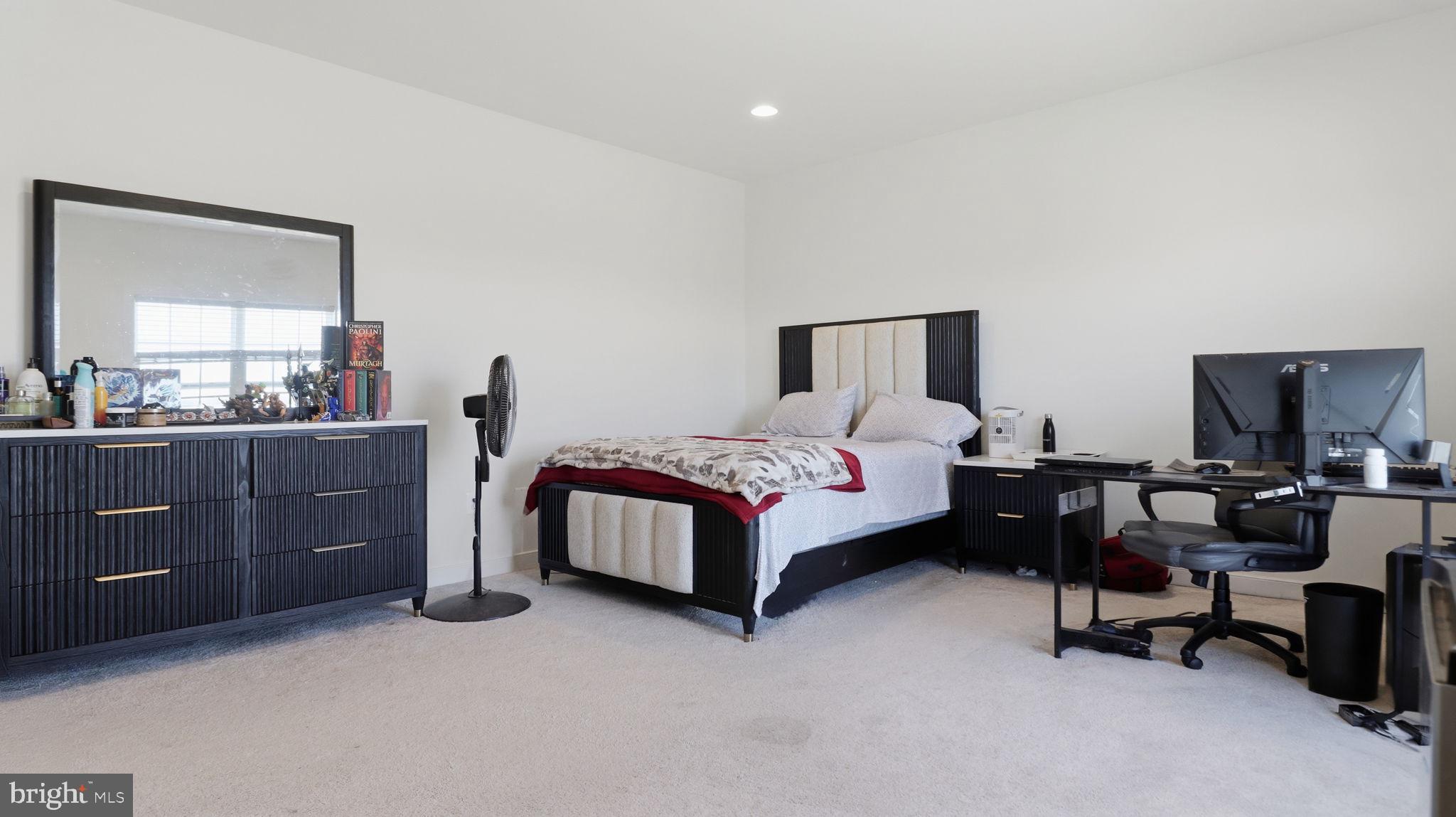 11502 Aden Road Nokesville, VA 20181 - Photo 54 of 106 a spacious bedroom with a bed and a table in it
