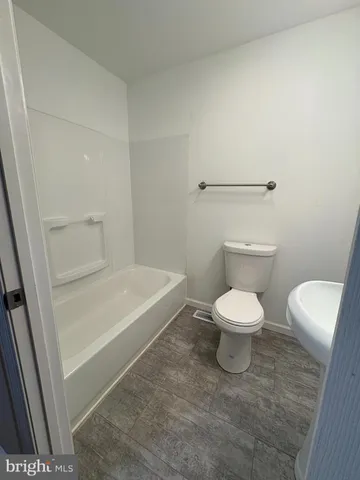 a white toilet sitting next to a bathroom sink