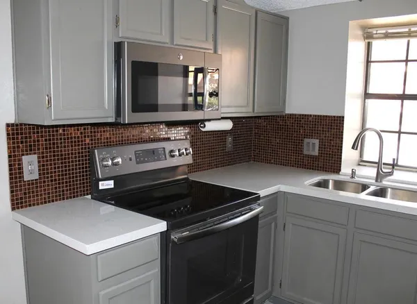 a kitchen with a sink stove and cabinets