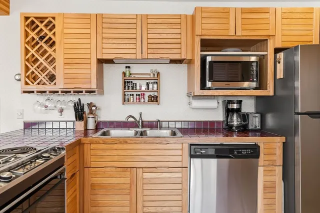 a kitchen with stainless steel appliances granite countertop a stove a sink and a microwave