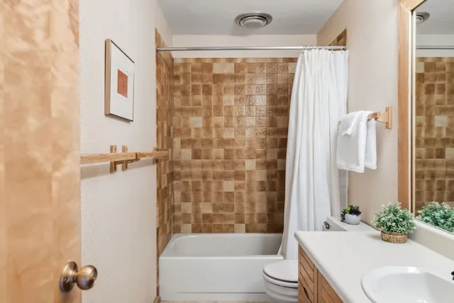 a bathroom with a sink a toilet and shower