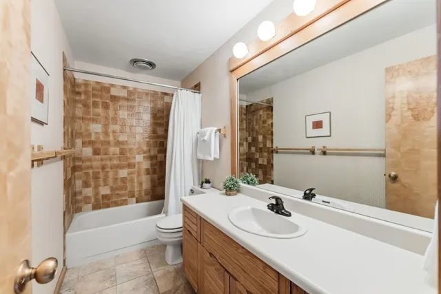 a view of a living room with a floor to ceiling window and wooden floor