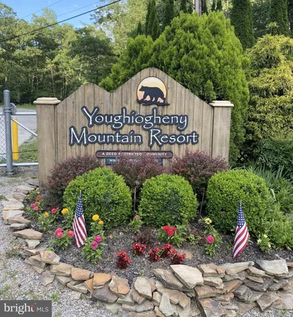 a view of sign board with plants and flowers