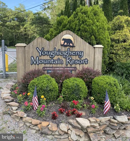a view of sign board with plants and flowers