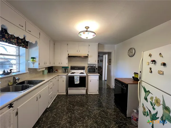 a kitchen with a sink stove and refrigerator
