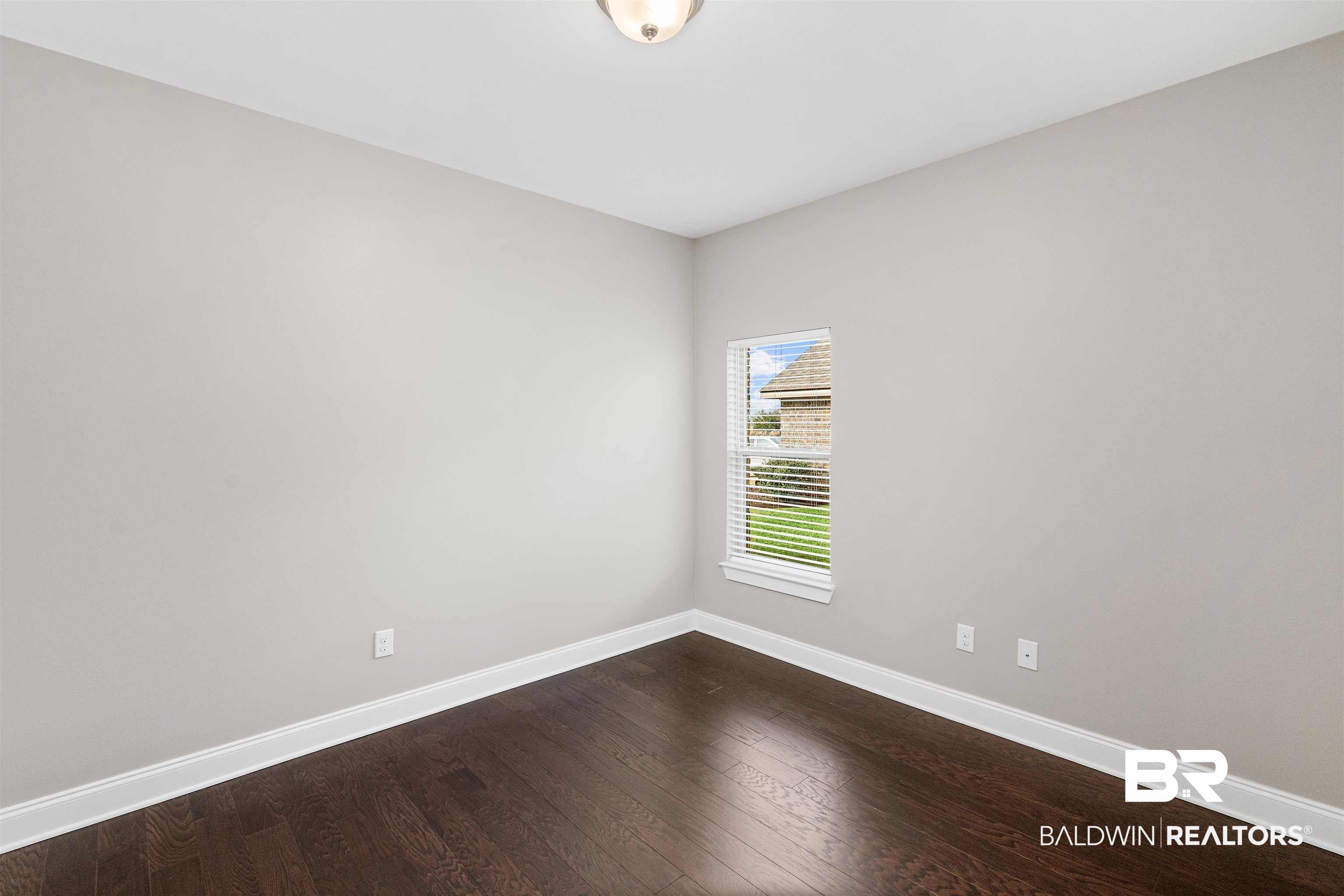 24838 Slater Mill Road Daphne, AL 36526 - Photo 28 of 46 Empty room featuring dark wood-style floors and baseboards