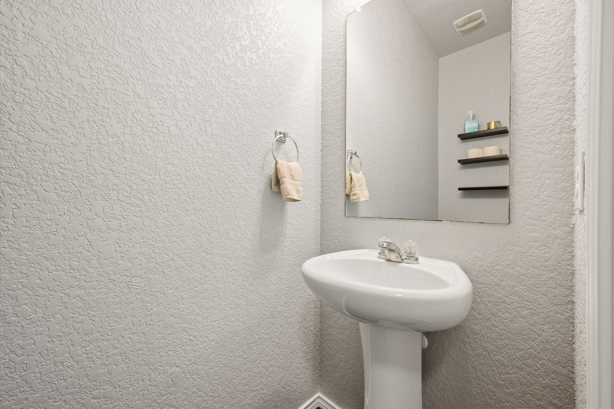 12007 Riprap Drive Manor, TX 78653 - Photo 21 of 37 A pristine pedestal sink with a gleaming mirror creates a functional and neat bathroom space.