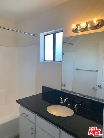a view of kitchen with granite countertop refrigerator stove top oven and sink