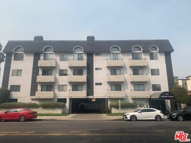 a couple of cars parked in front of a building