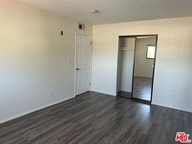 an empty room with wooden floor and closet