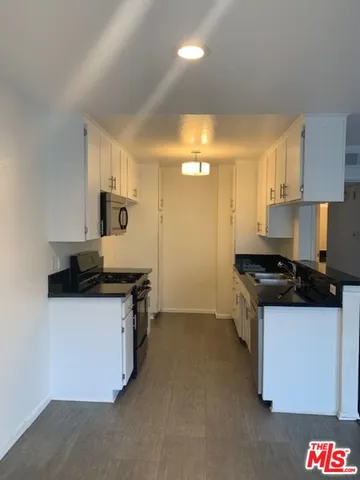 a kitchen with granite countertop a sink and a stove top oven