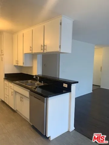 a kitchen with granite countertop a sink stove and cabinets