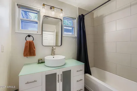 a bathroom with a sink vanity tub and a mirror