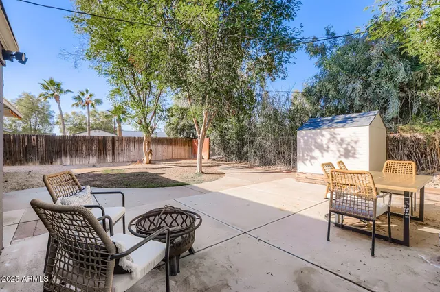 a view of a patio with a table and chairs and potted plants