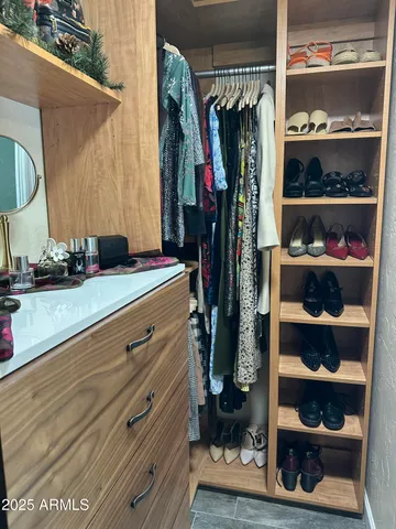 a view of walk in closet with clothes and shoes
