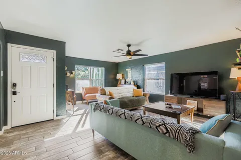 a living room with furniture a flat screen tv and kitchen view