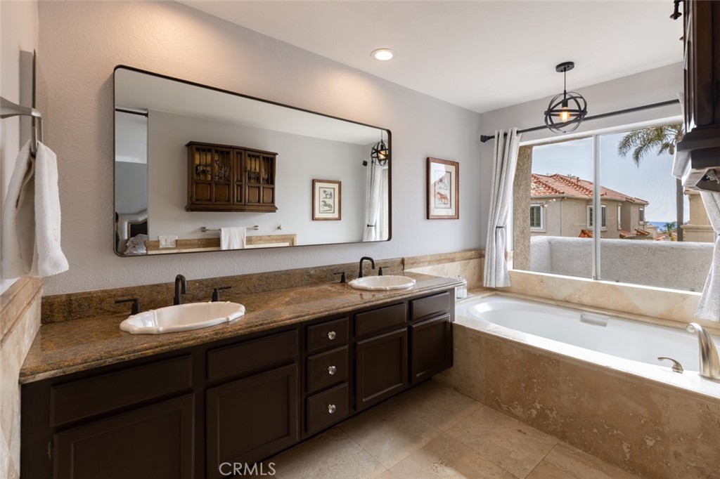 20 St Michael Dana Point, CA 92629 - Photo 17 of 43 a spacious bathroom with a granite countertop double vanity sink a mirror and a bathtub