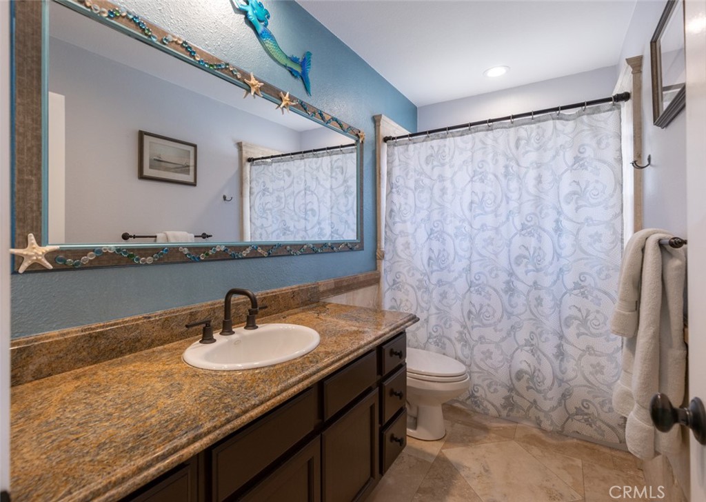 20 St Michael Dana Point, CA 92629 - Photo 32 of 43 a bathroom with a granite countertop sink a toilet and a mirror