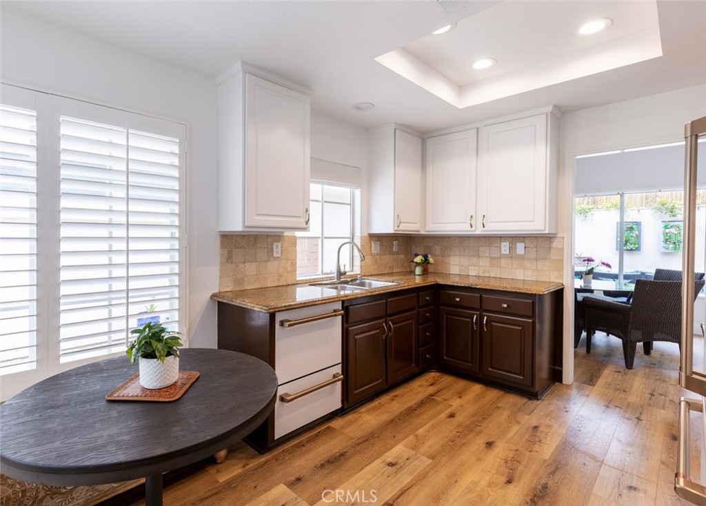 20 St Michael Dana Point, CA 92629 - Photo 10 of 43 a kitchen with stainless steel appliances granite countertop a stove a sink a refrigerator a dining table and chairs with wooden floor