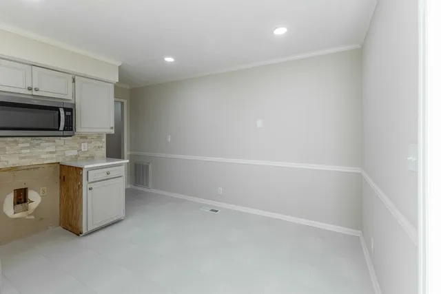 a view of a kitchen with a sink microwave and cabinets