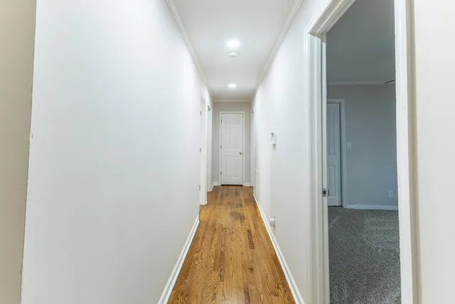 a view of a hallway with wooden floor and staircase