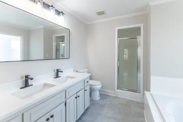 a bathroom with a double vanity sink mirror and toilet