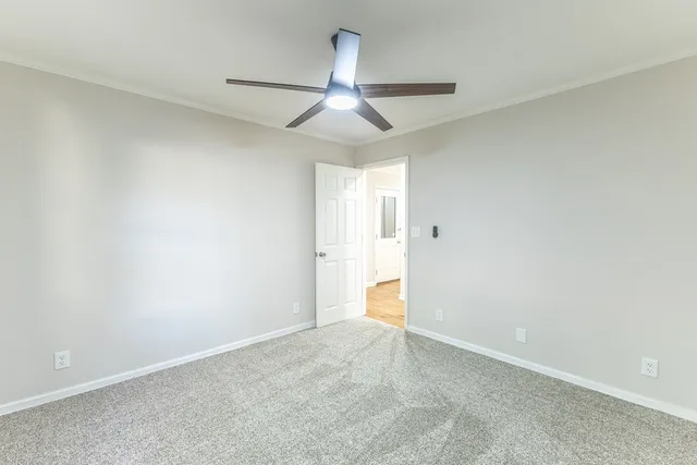 an empty room with a ceiling fan and a window