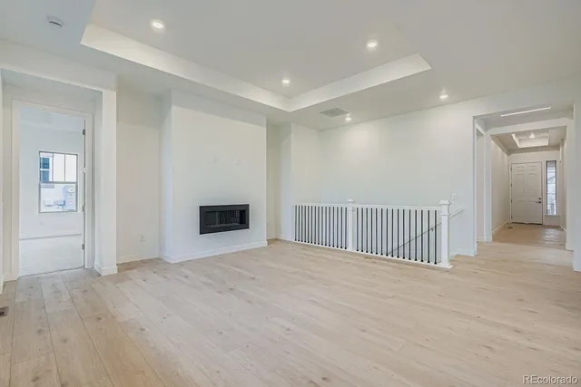a view of a hallway with wooden floor and a living room