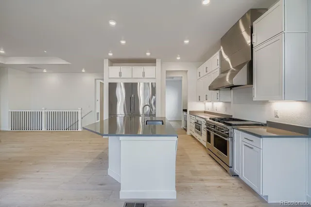 a kitchen with stainless steel appliances granite countertop a stove a refrigerator and a sink