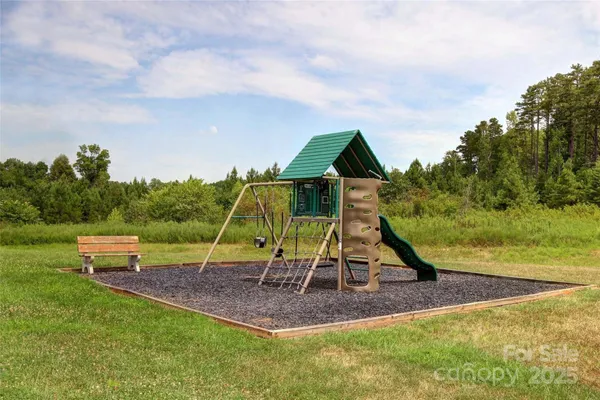 a view of outdoor space with playground and green space