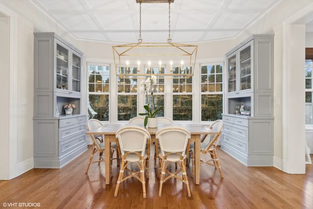 a dining room with furniture a chandelier and wooden floor