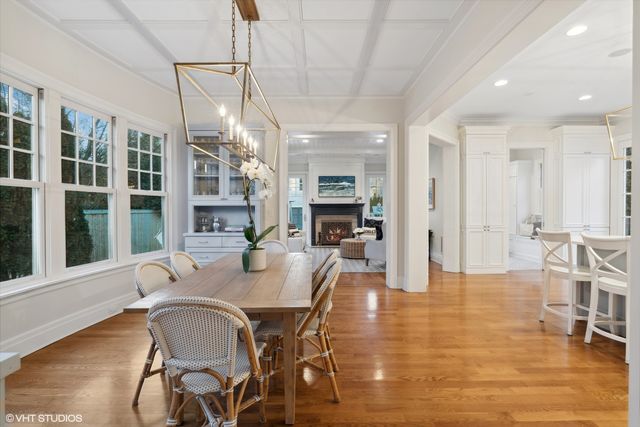 a dining room with furniture a chandelier and wooden floor