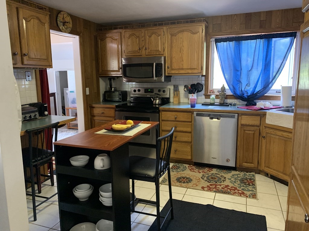 60 Gregory Road Framingham, MA 01701 - Photo 5 of 14 a kitchen with a sink a stove and chairs