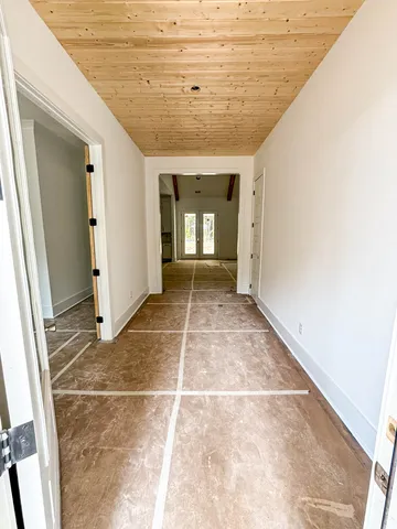 a view of a hallway with wooden floor and a window