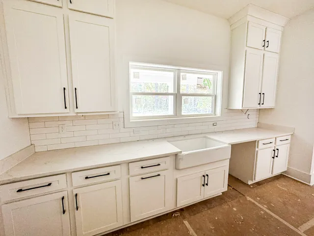 a kitchen with white cabinets white appliances and a sink