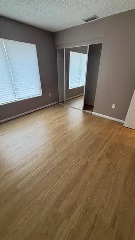 an empty room with wooden floor and cabinet