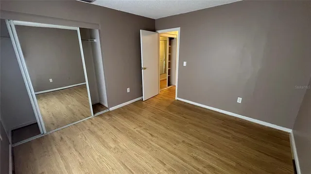 an empty room with wooden floor and entrance