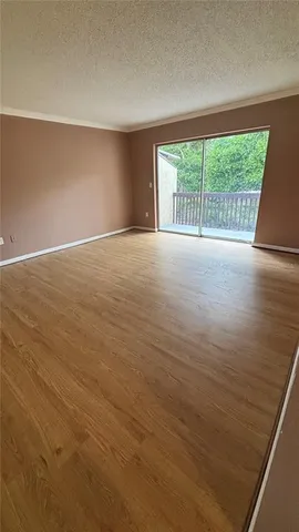 an empty room with wooden floor and outdoor view
