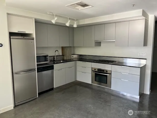 a kitchen with a refrigerator stove and white cabinets