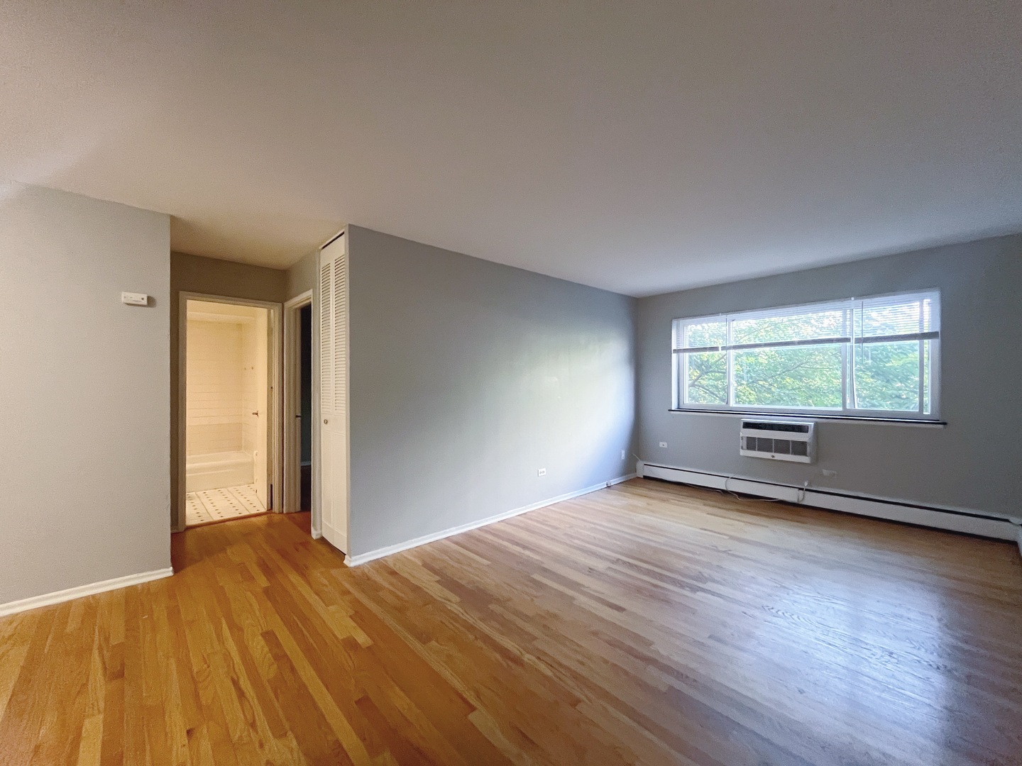 736 West Buena Avenue, Unit 307 Chicago, IL 60613 - Photo 2 of 9 a view of an empty room with wooden floor and a window
