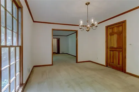 a view of a big room with windows and chandelier fan