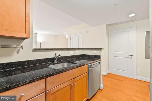 a kitchen with granite countertop a sink and a stove