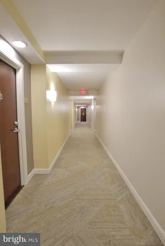 a living room with couches a coffee table and kitchen view with a large window