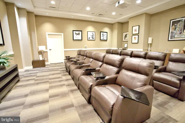 a large dining hall with stainless steel appliances granite countertop a refrigerator a stove and a dining table with wooden floor