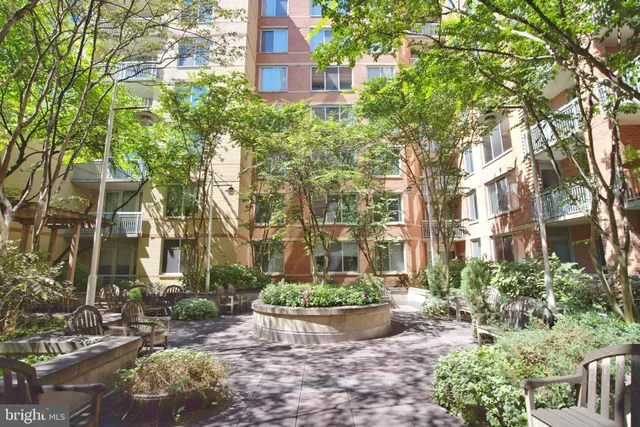 a view of a brick house with a yard and large tree