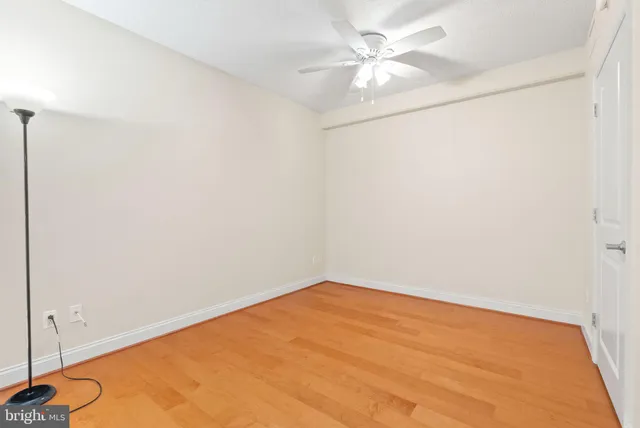 an empty room with a ceiling fan and a window